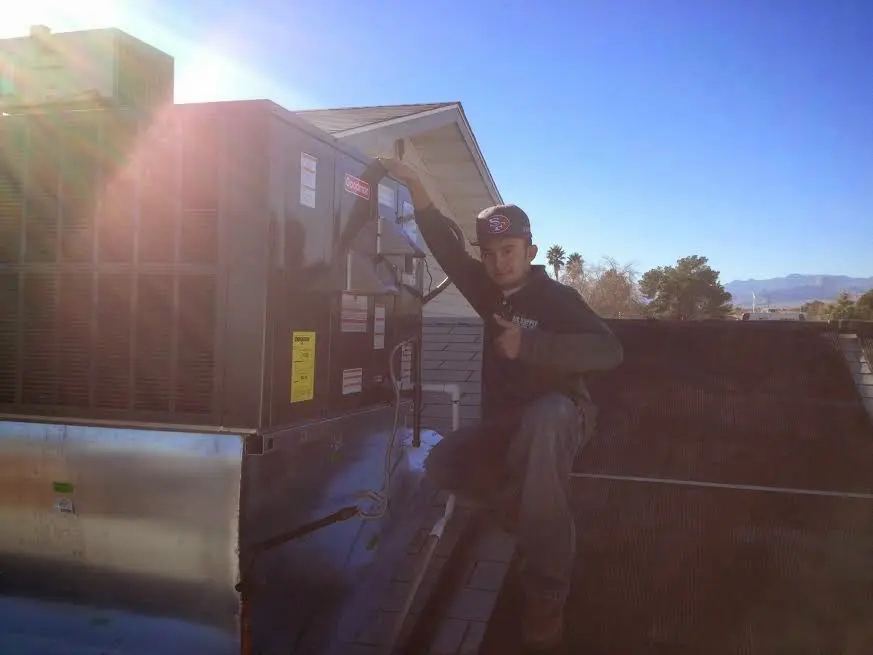 HVAC technician performing AC Tune-Up on a rooftop unit in East Cleveland
